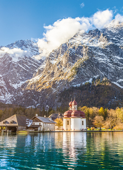 Panoramic view of scenic mountain scenery with Lake Konigssee with world famous Sankt Bartholomae (St. Bartholomew) pilgrimage church in fall, Nationalpark Berchtesgadener Land, Bavaria, Germany.