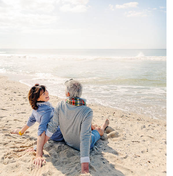 Senior couple sitting relaxed on beach of Westerland, Sylt, Germany.