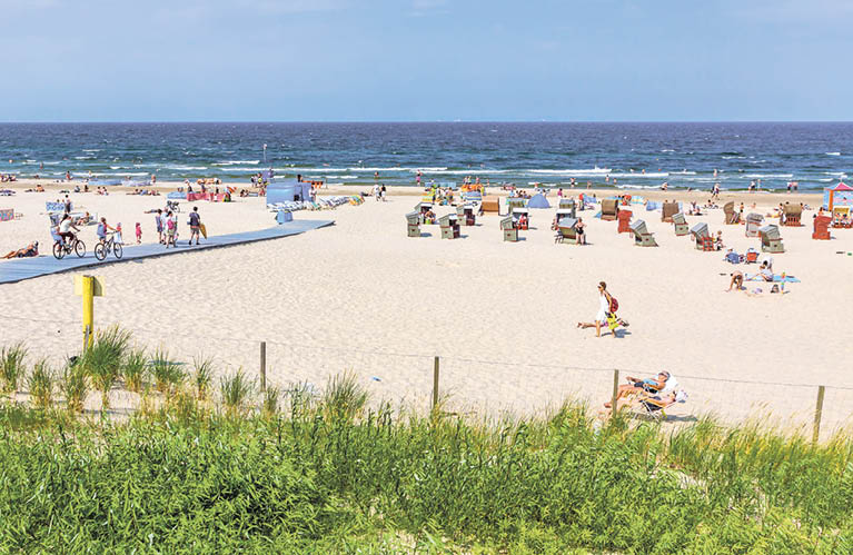 Сrowded Baltic beach on Usedom island in Swinoujscie resort, Poland. It borders the German seaside resort of Ahlbeck, both are freely connected by 12km of beach promenade